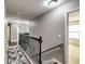Upstairs hallway with a decorative rug and dark wood railing at 6990 Annie Walk, Lithonia, GA 30038