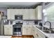 The bright kitchen has white cabinets, stainless steel appliances, and a marble countertop at 6990 Annie Walk, Lithonia, GA 30038