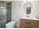 Modern bathroom features a glass-enclosed shower, a stylish vanity, and a unique lighted mirror at 815 Tanner Rd, Dacula, GA 30019