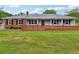 Charming single-story home featuring a brick facade, metal roof and well-maintained landscaping at 815 Tanner Rd, Dacula, GA 30019