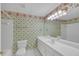Bathroom with white vanity, large mirror, and unique floral wallpaper at 1405 Wilmington Way, Grayson, GA 30017