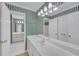 Bathroom with vanity and a large mirror, complimented by green striped wallpaper at 1405 Wilmington Way, Grayson, GA 30017