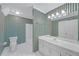 Bathroom featuring a white vanity, toilet, shower and green striped wallpaper at 1405 Wilmington Way, Grayson, GA 30017