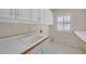 Functional laundry room featuring white cabinets, counter space, and a window at 1405 Wilmington Way, Grayson, GA 30017