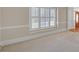Sunlit living room with plush carpet and white shuttered windows at 1405 Wilmington Way, Grayson, GA 30017