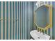 Charming powder room featuring striped wallpaper and a gold-trimmed mirror, adding a touch of elegance to your home at 1405 Wilmington Way, Grayson, GA 30017