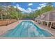 Large community swimming pool with clear blue water, surrounded by a spacious deck and shaded seating area at 1405 Wilmington Way, Grayson, GA 30017