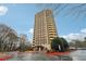 Modern high-rise apartment building with covered entry, parking, and mature trees at 1501 Clairmont Rd # 1624, Decatur, GA 30033
