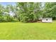 Expansive backyard view, showcasing a vast green lawn, surrounding trees and outbuildings at 2940 Blue Sky Pl, Marietta, GA 30068