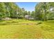 A large backyard featuring a well-maintained lawn and a stream with lush green trees at 2940 Blue Sky Pl, Marietta, GA 30068