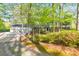 Home exterior with lush trees, a long driveway, and a spacious three-car garage at 2940 Blue Sky Pl, Marietta, GA 30068