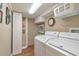 Bright laundry room with white washer, dryer, and overhead storage at 2940 Blue Sky Pl, Marietta, GA 30068