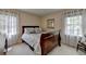Cozy bedroom showcasing a wooden sleigh bed, soft lighting, and sheer curtains at 5023 Buckline Xing, Dunwoody, GA 30338