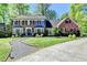 Charming brick home featuring a well-manicured lawn, mature trees, and a welcoming front entrance at 5023 Buckline Xing, Dunwoody, GA 30338