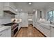 Well-lit kitchen with white cabinets, subway tile backsplash, and hardwood floors at 5023 Buckline Xing, Dunwoody, GA 30338