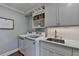 Well-organized laundry room with white cabinets, marble counters, and modern washer/dryer at 5023 Buckline Xing, Dunwoody, GA 30338