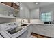 Well-appointed laundry room with white cabinetry, marble countertops, and modern appliances at 5023 Buckline Xing, Dunwoody, GA 30338