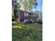 Angle view of a two-story home with a two-car garage surrounded by lush trees at 6150 Silver Spur Dr, Lithonia, GA 30058