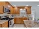 Attractive kitchen featuring stainless steel appliances, wooden cabinetry, granite counters, and tile floor at 4366 Karls Gate Dr, Marietta, GA 30068