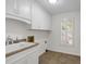 Clean laundry room with tile flooring, white cabinets, and a window with plantation shutters at 4366 Karls Gate Dr, Marietta, GA 30068