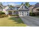 Charming two-story home featuring a well-manicured lawn, inviting porch, and a two-car garage at 5724 Kendrick Ln, Cumming, GA 30041