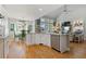 Open-concept kitchen with stainless steel appliances, hardwood floors, and a seamless transition to the living room at 5724 Kendrick Ln, Cumming, GA 30041