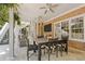 Covered patio featuring brick wall with mounted television, dining and lounging spaces at 5724 Kendrick Ln, Cumming, GA 30041