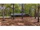 Quaint brick home nestled among mature trees, featuring green shutters and a cozy, inviting setting at 285 Glen Ne Rd, Conyers, GA 30013