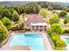Aerial view of community clubhouse and pool featuring outdoor seating, mature trees, landscaping, and ample deck space at 322 Tupelo Tr Trl, Canton, GA 30114