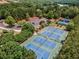 An aerial view showcasing community tennis courts and parking surrounded by mature trees and lush landscaping at 322 Tupelo Tr Trl, Canton, GA 30114