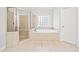 Well-lit bathroom featuring a glass-enclosed shower and separate soaking tub at 322 Tupelo Tr Trl, Canton, GA 30114