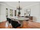 Elegant dining room with modern table, black chairs, hardwood floors, and chandelier at 322 Tupelo Tr Trl, Canton, GA 30114