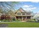Charming two-story home featuring a stone and brick facade, a covered porch, and manicured landscaping at 322 Tupelo Tr Trl, Canton, GA 30114