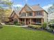 Traditional two-story brick home with a welcoming front porch and manicured lawn at 322 Tupelo Tr Trl, Canton, GA 30114