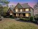 Stunning two-story home boasts a brick and stone facade, covered porch and lush landscaping at 322 Tupelo Tr Trl, Canton, GA 30114