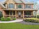 Inviting two-story home with covered front porch, manicured lawn, and beautiful landscaping at 322 Tupelo Tr Trl, Canton, GA 30114