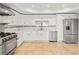 Well-equipped kitchen with stainless steel appliances, white cabinets, and tile backsplash at 322 Tupelo Tr Trl, Canton, GA 30114