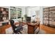 Comfortable home office with hardwood floors, built-in shelving, and a large desk at 322 Tupelo Tr Trl, Canton, GA 30114