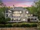 Back of house at twilight featuring a two-story screened in porch and large decks overlooking the well-manicured lawn at 322 Tupelo Tr Trl, Canton, GA 30114