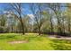 Spacious backyard with lush green lawn, mature trees, and a cozy fire pit at 4504 Union Hill Rd, Canton, GA 30115
