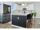 Bright kitchen boasts an island with bar seating, stainless steel refrigerator, and modern pendant lighting at 1332 Nw Creekside Cir, Atlanta, GA 30318
