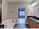 Bright bathroom with a large soaking tub, a dual sink vanity with granite countertops, and access to an adjacent room at 1668 Sabastian Ne Pt, Atlanta, GA 30329