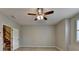 This spacious bedroom features a ceiling fan, neutral paint, wood floors, and a doorway to the staircase at 1668 Sabastian Ne Pt, Atlanta, GA 30329