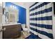 Stylish bathroom with a blue accent wall, striped shower curtain, and modern vanity at 5157 Madeline, Stone Mountain, GA 30083