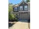 Inviting townhouse exterior featuring stone accents, a two-car garage, and lush greenery at 5157 Madeline, Stone Mountain, GA 30083