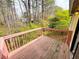 A wooden deck with a red railing overlooks a wooded area offering a private outdoor space at 6092 Leverett Dr, Lithonia, GA 30038