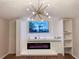Stylish living room with modern fireplace, built-in shelves, and a unique chandelier at 6092 Leverett Dr, Lithonia, GA 30038
