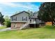 Split-level home featuring a stone foundation, gray siding, front stairs, and well-manicured lawn at 2015 Brookstone Ct, Lithia Springs, GA 30122