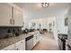 Well-lit kitchen featuring granite countertops, white cabinets, and stainless steel appliances at 3647 Bancroft Main Nw, Kennesaw, GA 30144