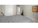 Neutral bedroom featuring a gray quilt bed, two guitars, wall shelf and two white doors at 3950 Almandine Way, Cumming, GA 30040